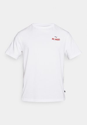 Balts kokvilnas T-krekls ar apaļu izgriezumu, īsām piedurknēm un sarkanu izšuvumu "St. Pauli" kopā ar mazu Puma logo.
