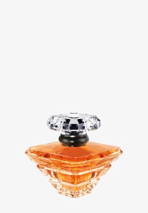 Flacon de parfum en cristal facetté contenant un liquide ambré, avec un anneau noir sous un bouchon clair aux multiples facettes, sur fond blanc.