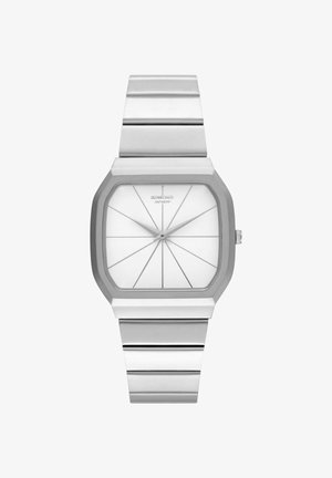 Montre en métal argenté avec un boîtier carré, cadran blanc présentant des lignes géométriques, et un bracelet en métal assorti avec un détail de maillons.