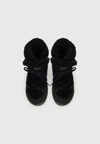 Bottes d'hiver noires, en peluche, avec un haut revers et un design à lacets, posées sur un fond blanc.