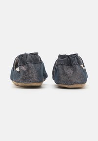 Sofistikert blå fløyels slip-on-sko med elastiske bakpartier og beige semsket såler, med subtil glans og et sømløst design.