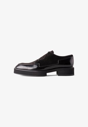 Black leather and suede men's loafer with thick platform sole and low block heel, viewed from the side on white background.