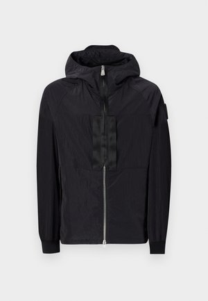 Black jacket made of lightweight fabric features a zip front, adjustable hood, and textured design with contrasting panel on the chest.