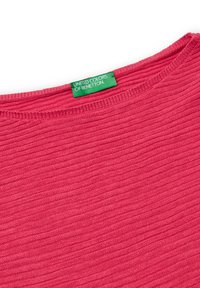 Rosa gerippter Strickpullover mit rundem Ausschnitt und einem grünen Etikett, das "United Colors of Benetton" liest. Weiche Textur und gleichmäßige Nähte.