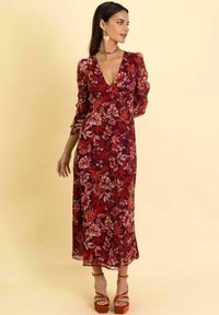 Langes, fließendes Kleid in Dunkelrot mit floralem Muster; der Stoff wirkt leicht. Verfügt über lange Puffärmel und einen tiefen V-Ausschnitt.