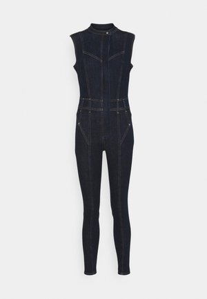 Denim jumpsuit med ærmeløs design, mørkeblå farve, tætsiddende silhuet, høj krave, frontlynlås og synlige syningsdetaljer.