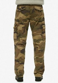 Pantalones cargo camuflados en tonos de verde y marrón, con bolsillos laterales, un corte holgado y un diseño de pierna recta con rodillas reforzadas.