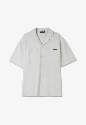 Šviesiai pilka trumpomis rankovėmis marškinėlių su mygtukais, su tekstūruota medžiaga, dviem priekinėmis kišenėmis ir smailiu apykakle. Ant krūtinės yra "PEGADOR" logotipas.