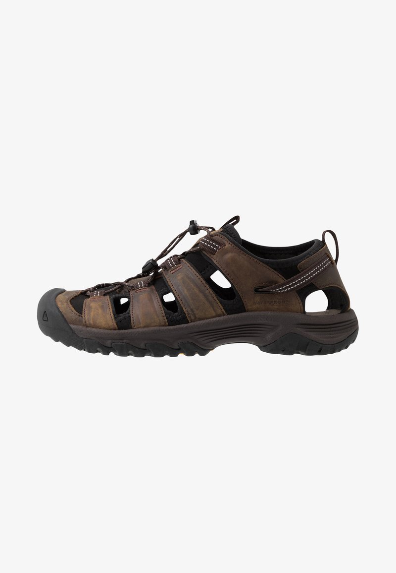 Braune Sandalen für den Außenbereich mit offenem Design, aus Leder und Mesh-Materialien, sicherem Schnürverschluss, gemusterten Akzenten und robuster Gummisohle.