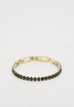 Bracelet doré avec des pierres noires alternées en rang, un design géométrique sur le fermoir et une finition polie.