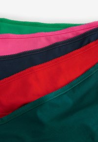 Ensemble de six bandes de tissu de différentes couleurs : vert, rose, marine, rouge, noir et vert foncé. Chaque bande présente un bord festonné.