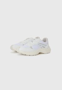 White sports shoes featuring mesh and synthetic materials, with light gray accents and a chunky sole, designed for comfort and support.