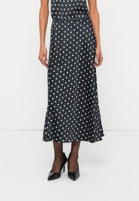 Črna midi krilo iz satena z belimi pikami, z gladko teksturo, rahlim razširjenjem na spodnjem robu in elastičnim pasom za udobje.