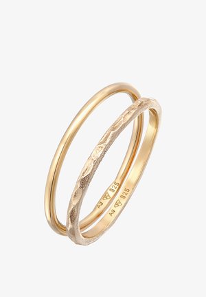 Dwie złote pierścionki: jeden gładki i okrągły, drugi z fakturowanym, falistym wzorem. Oba oznaczone stempelkiem "925" dla zawartości srebra.