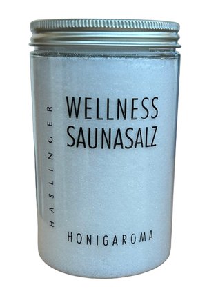Klarer Plastikbehälter mit silbernem Schraubdeckel, gefüllt mit weißem Wellness-Saunasalz, beschriftet mit "Haslinger Wellness Saunasalz Honigaroma".