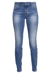 Jeans de mezclilla azul con un ajuste slim, que presentan un ligero desgaste en la parte frontal y en los bolsillos traseros, cierre de botón y presillas para el cinturón.