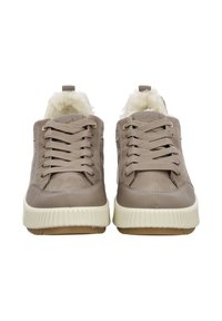 Zapatillas deportivas gruesas en beige con parte superior de cuero liso, cordones texturizados, forro suave de piel sintética y suela gruesa de goma blanca.