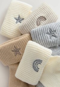 Ribbad strumpor i beige, krämfärgad och grå med broderade stjärnor och regnbågar. Mjuk textur med distinkta färger och mönster.