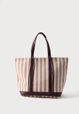 Bolsa de tela con rayas verticales beige y granate, asas y base de cuero granate, apoyada sobre un fondo claro.