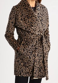 Abrigo de estampado de leopardo hecho de tela suave, con un amplio cuello, cinturón de lazo y dos bolsillos laterales. Los colores incluyen beige, negro y marrón.
