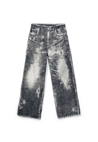 Jeans larges délavés noir et blanc avec plusieurs patchs effilochés et ourlet brut, étalés à plat sur un fond blanc.