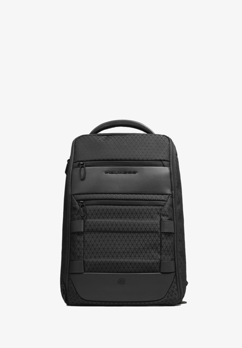 Sac à dos noir avec motif en losange texturé, plusieurs poches zippées, accents en cuir et une poignée supérieure pour le transport. Design compact et fonctionnel.