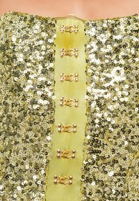 Arany flitterekkel díszített, pánt nélküli felső, zöld selyempanellel és arany fémzárakkal az elején.