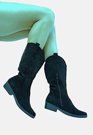 Botas hasta la rodilla de ante negro con costuras decorativas, cremallera lateral y tacón bajo cuadrado. El diseño presenta un delicado patrón de hojas.