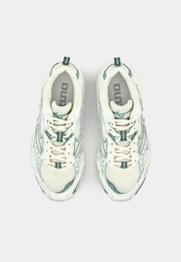 Zapatillas deportivas blancas con acentos en verde azulado, parte superior de malla y sintético, puntera redonda, suela texturizada y logotipo en la lengua y el talón.