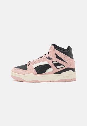 Sneaker montante avec panneaux en suède rose et cuir noir, semelle intermédiaire crème et semelle extérieure rose, présenté de profil sur un fond blanc.