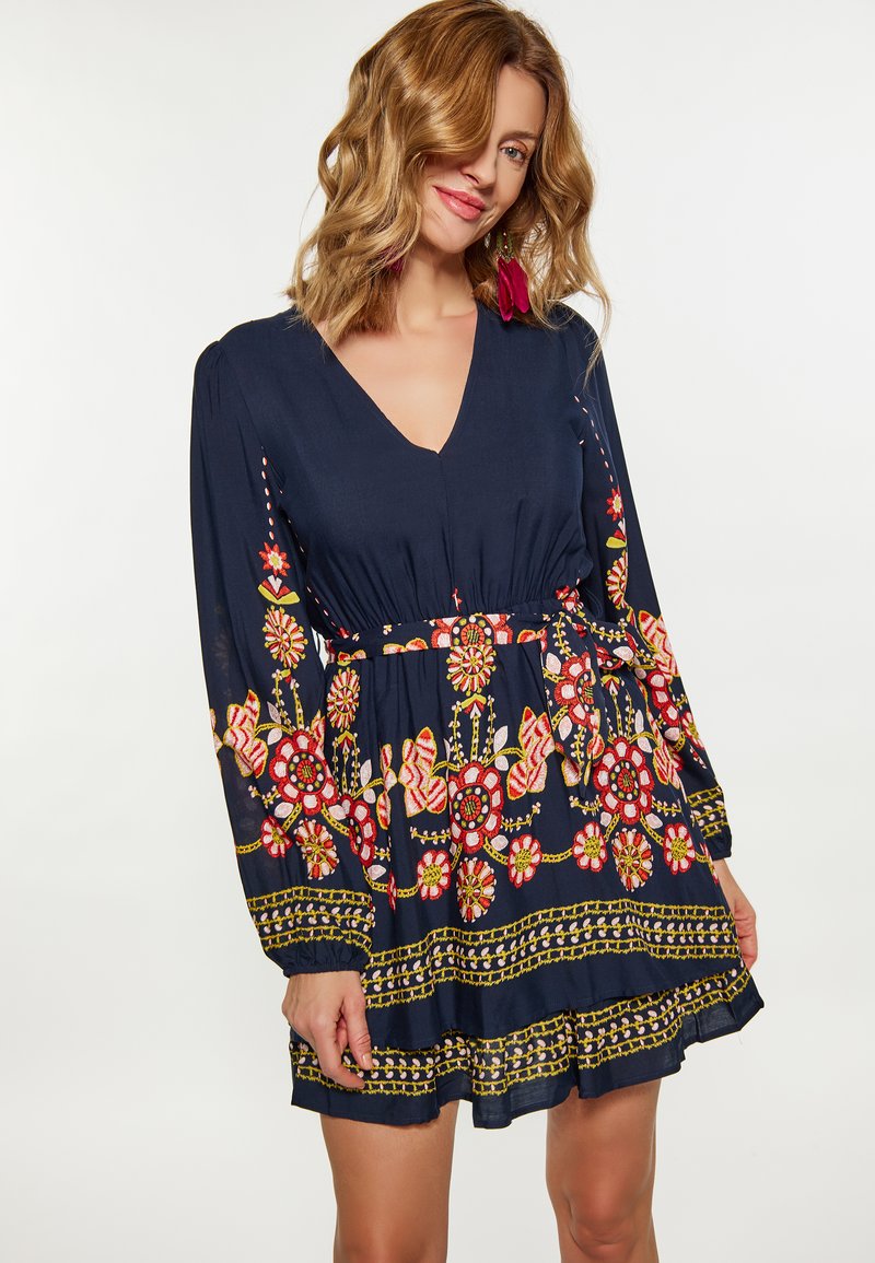Rochie bleu marin cu mâneci lungi, decolteu în V, talie strânsă și broderie florală intricate în roșu și galben, evidențiind o fustă stratificată.