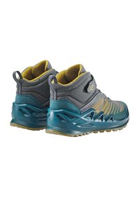 Scarpe da trekking grigie e teal con una tomaia testurizzata, supporto alla caviglia aderente, accenti gialli e suola robusta progettata per la trazione.