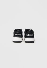 Czarno-białe sneakersy marki Just Cavalli pokazane od tyłu na jednolitym białym tle.
