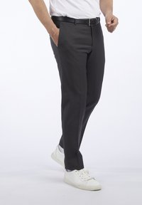 Pantalon gris ajusté en tissu tissé, avec une coupe slim, une taille plate et des poches latérales, assorti de baskets blanches.