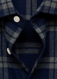 Camicia a quadri navy con linee grigie, tessuto morbido, chiusura con bottoni e colletto a punta. Texture notevoli migliorano l'aspetto complessivo.
