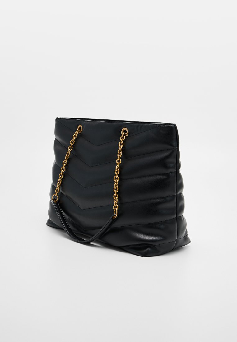 Bolso tote de cuero negro con diseño acolchado en forma de chevron, con asas de cadena dorada y una textura suave.