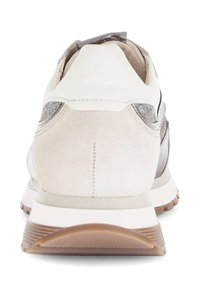 Witte sneaker met suède en metalen accenten, afgeronde vorm, gevoerde hiel en gestructureerde buitenzool voor grip. Zichtbare stiksels en contrasterende materialen.