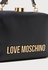 Black leather handbag with gold clasp and "LOVE MOSCHINO" gold lettering on front, featuring black leather handle with gold hardware.