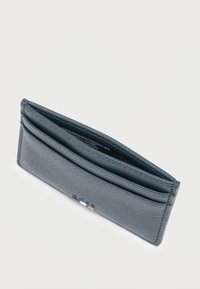 Harmaa nahkainen korttikotelo useilla lokerikoilla, teksturoidulla pinnalla, kompakti suorakulmainen muoto, jossa etupuolella hillitty logodetalji.