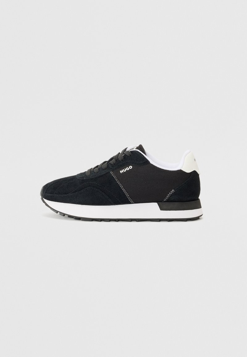 Baskets basses noir et blanc avec panneaux en daim et en mesh, col rembourré blanc, lacets noirs et logo "HUGO" sur le côté.