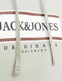Jasnoszara bluza z kapturem z troczkami, z przodu z nadrukiem w odważnym czarnym i brązowym tekscie, w tym "JACK&JONES" oraz "ORIGINALS WORLDWIDE."