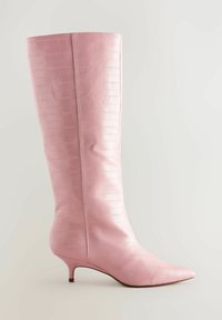 Botín de cuero rosa hasta la rodilla con punta afilada, superficie texturizada y un tacón kitten delgado, con un acabado suave y brillante.