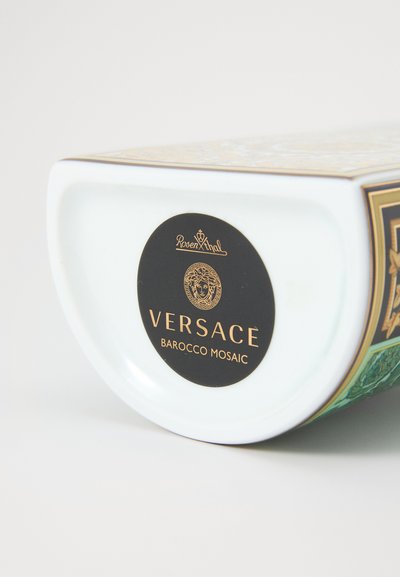 Recipiente de cerâmica com base branca brilhante, design Barocco Mosaic em cores vibrantes, e etiqueta preta com a palavra "Versace" e detalhes decorativos.