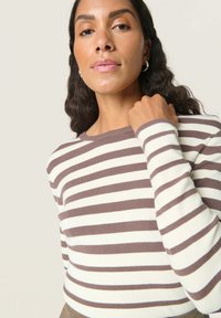 Stribet langærmet sweater i creme og brun, ribbet tekstur, klassisk rund hals, tætsiddende facon, med en glat finish og sideskær.