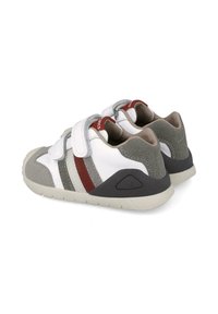 Zapatos blancos con acentos de ante gris y rayas rojas. Cuentan con correas de Velcro, una suela de goma y una puntera redondeada.
