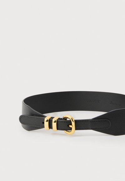 Ceinture en cuir noir texturé avec une boucle dorée et deux passants dorés, posée à plat sur une surface blanche.