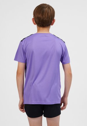 Fioletowa sportowa koszulka z krótkim rękawem z czarnymi akcentami na ramionach, wykonana z gładkiego materiału, prezentowana na dziecku od tyłu. Standardowy krój.
