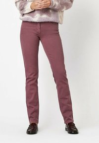 Burgunderfarbene gerade Jeans aus hochwertigem Baumwollgemisch, mit mittlerer Taille und einfacher Steppnaht. Kombiniert mit dunklen Slippern.