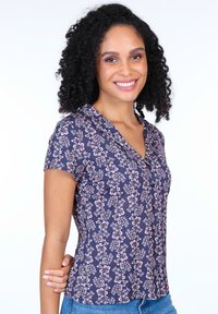 Navy short-sleeve top with a collar featuring a floral pattern in pink and white. Soft fabric with a fitted shape.