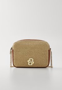 Tkaná béžová kabelka s texturovaným povrchem, hnědými koženými akcenty a řetízkovým popruhem. Na přední straně se nachází výrazné zlaté logo.